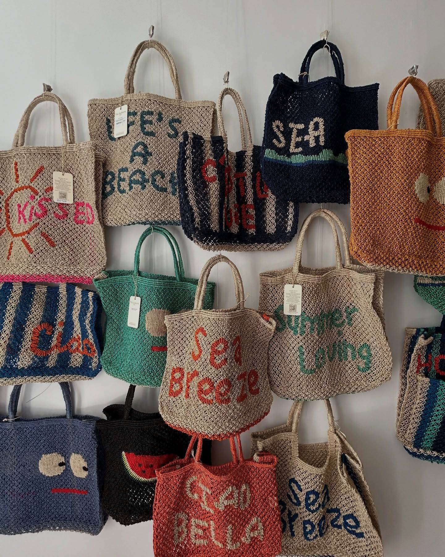 A wall filled with handwoven bags in playful colors