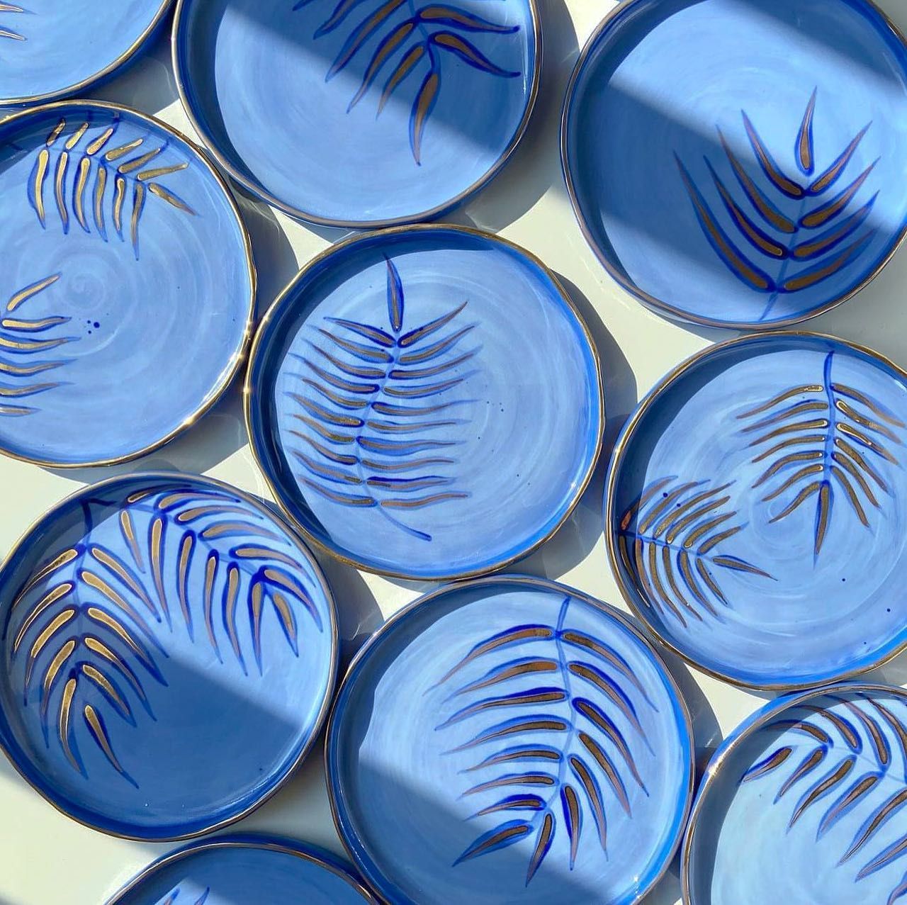 Cobalt blue handmade plates decorated with gold palm fronds